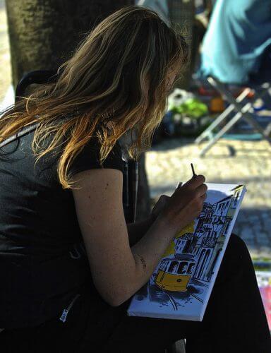 A girl draws outside as an example of healthy coping mechanisms