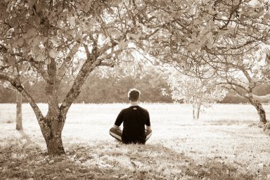 a sepia image of a man meditating under some trees represents the best tips for meditation