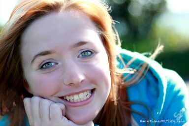 A woman with red hair smiles into the camera happy that she is experiencing radiant recovery