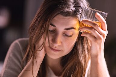 Woman drinking a hard liquor alcoholic drink