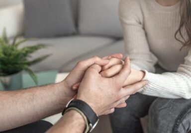 Couple holding hands in support of mental health issues