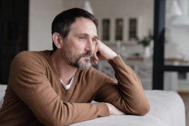 Middle-aged man looking far away thinking negative thoughts