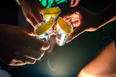 Group of people toasting shots of tequila