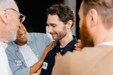 Man surrounded by people from his addiction recovery group